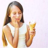 Child experiencing tooth sensitivity from cold ice cream